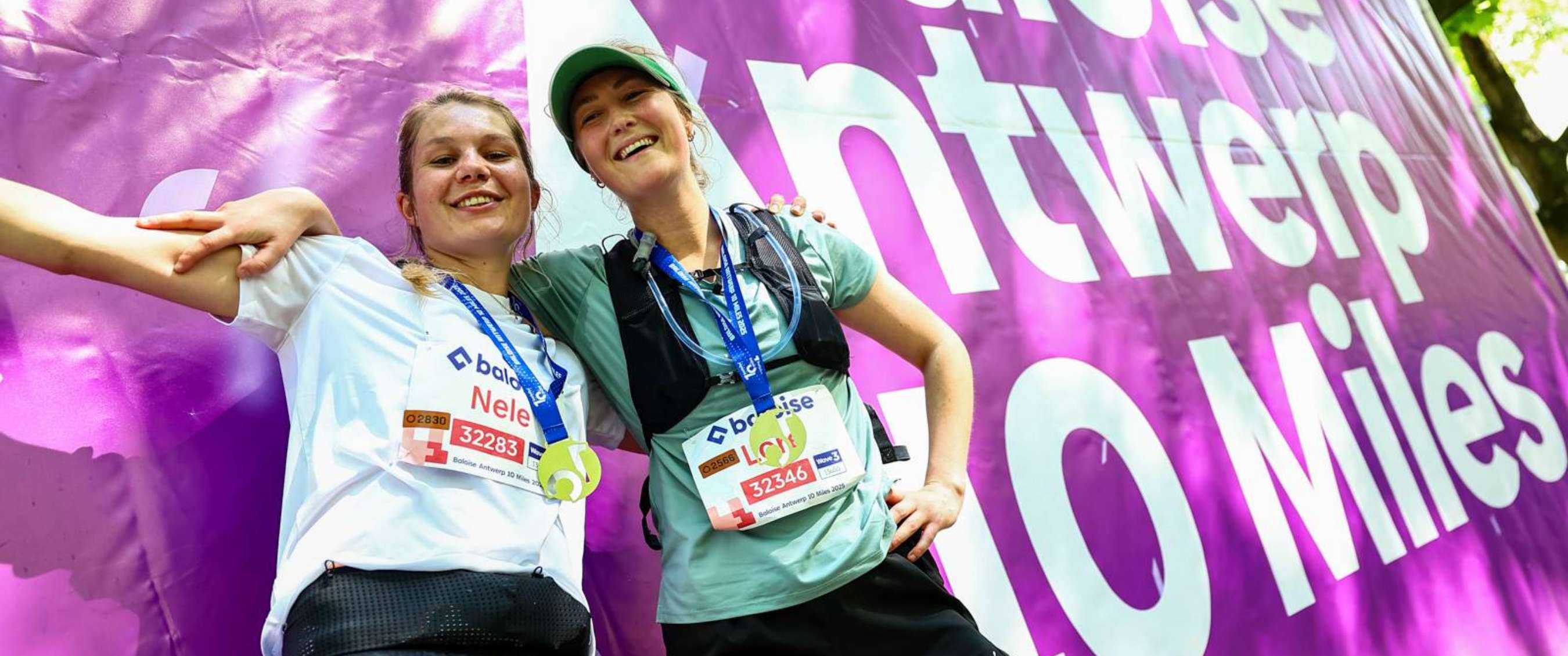 Loopsters met startnummer en medaille na afloop van de “Baloise Antwerp 10 Miles”.