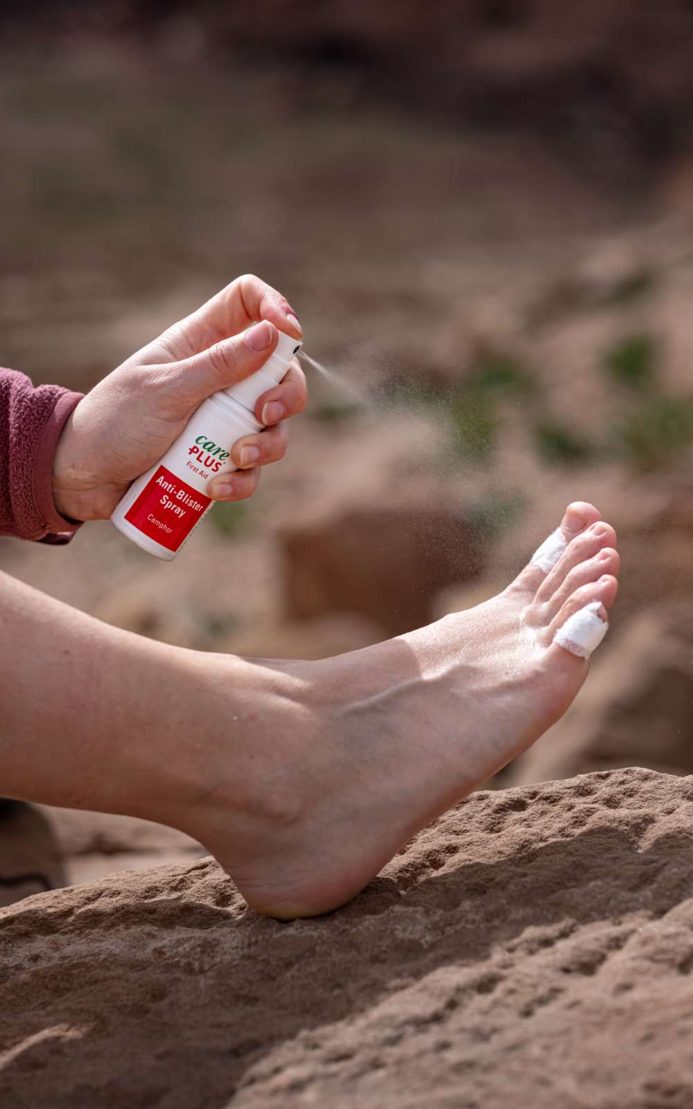 Care Plus Anti-Blister Spray wordt aangebracht op een voet met een verbonden teen.