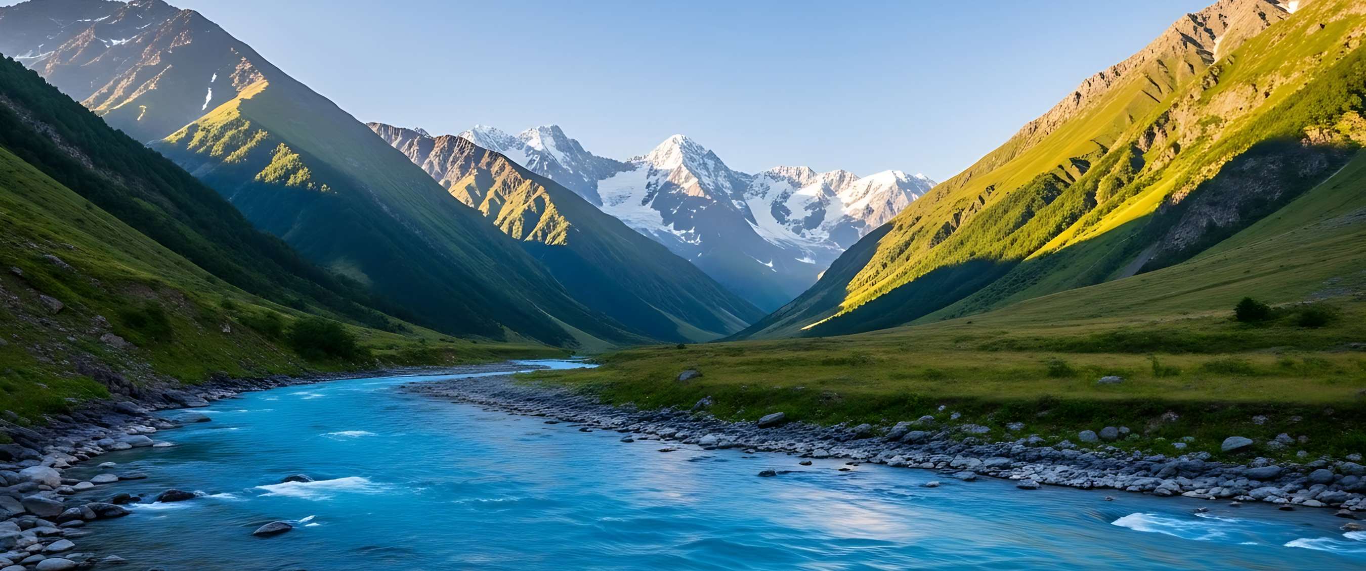 Helderblauwe rivier stroomt door groene bergvallei met besneeuwde toppen