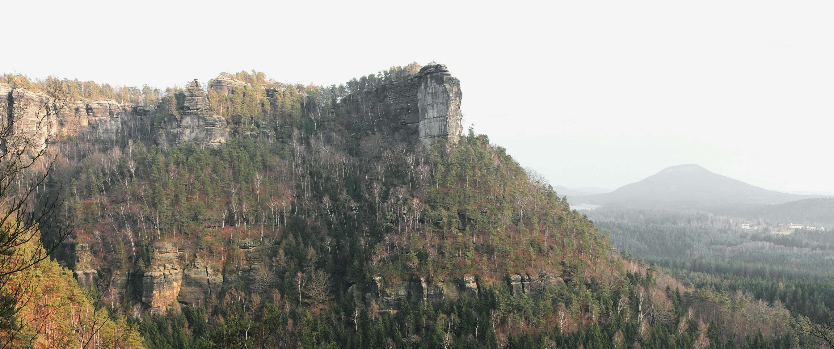 Twee beelden: mist trekt door een rotsachtig berglandschap; koe staat in een weide met bomen.