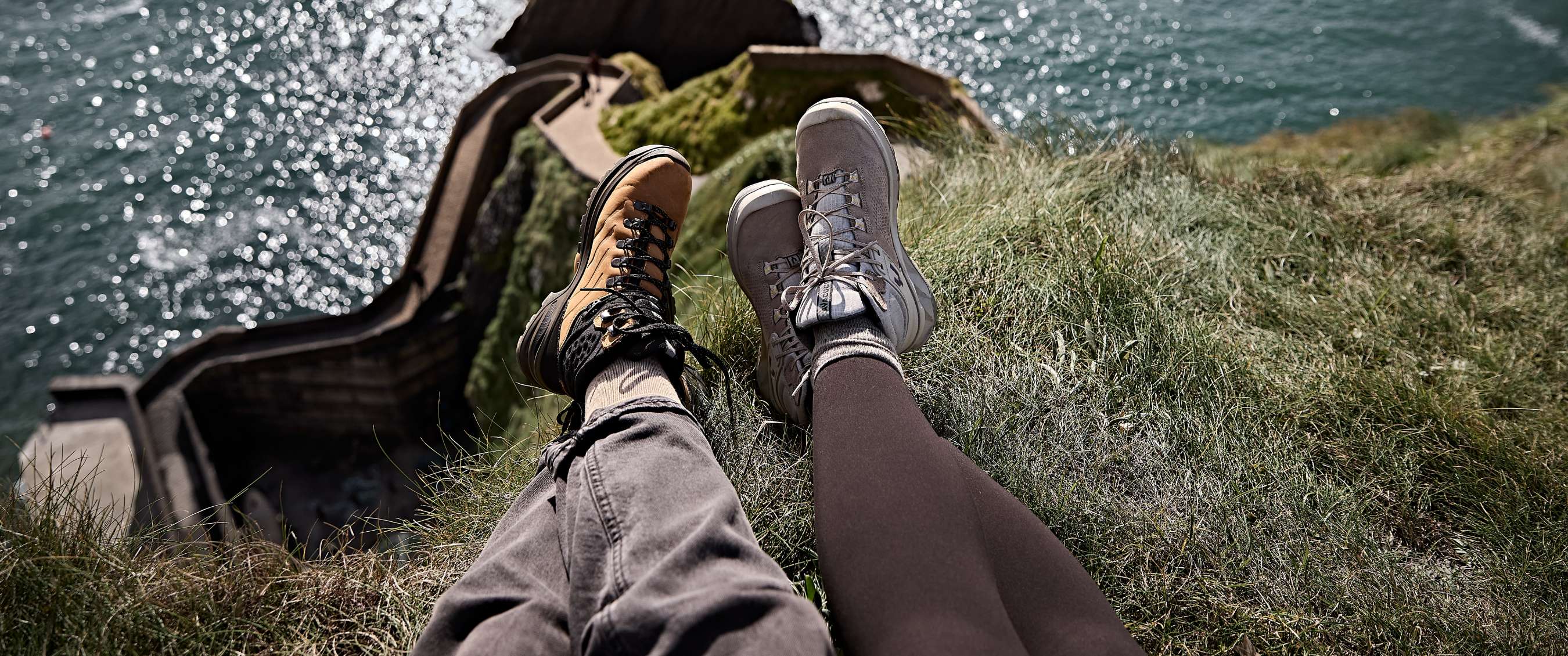 Twee beelden: Benen met hiking boots op grasrand met uitzicht op water en rotsen.