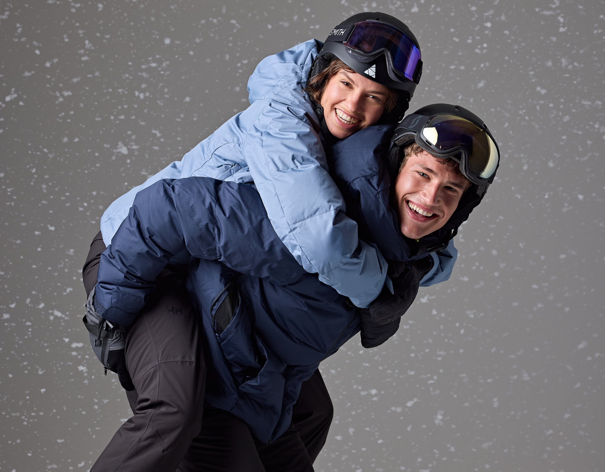 Twee personen lachen terwijl de een de ander op de rug draagt.